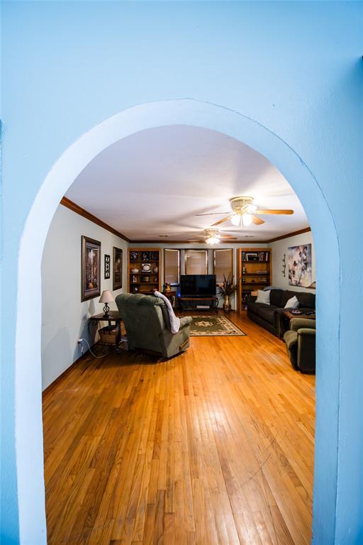23281 N Pvt 3227 Dr, Pauls Valley, OK 73075 - living area with a ceiling fan, arched walkways, hardwood / wood-style flooring, and crown molding