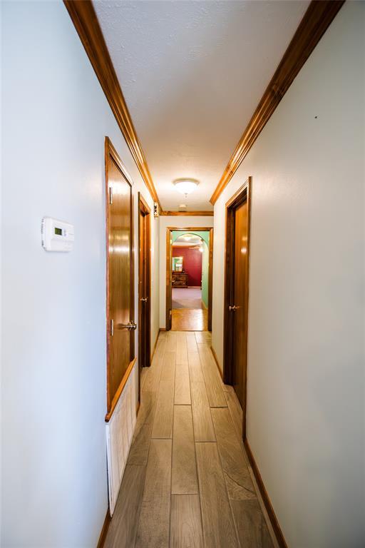 23281 N Pvt 3227 Dr, Pauls Valley, OK 73075 - hallway with ornamental molding, light wood finished floors, and arched walkways