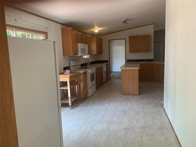 128 N Buffalo St, Canadian, OK 74425 - kitchen featuring white appliances, a kitchen island, lofted ceiling, brown cabinets, and light countertops