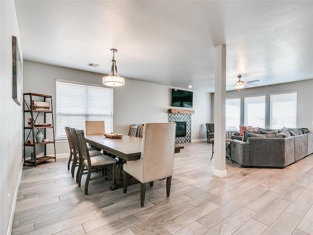 1417 Atalon Dr, Moore, OK 73160 - dining room with a tile fireplace, light wood-style floors, and ceiling fan