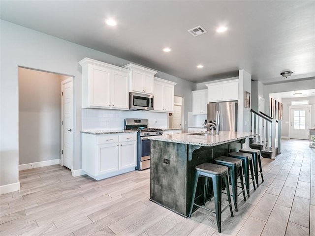 1417 Atalon Dr, Moore, OK 73160 - kitchen with stainless steel appliances, light wood-style flooring, light stone counters, and recessed lighting