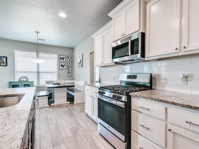 1417 Atalon Dr, Moore, OK 73160 - kitchen featuring stainless steel appliances, decorative backsplash, white cabinets, pendant lighting, and light stone countertops