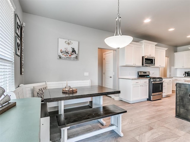 1417 Atalon Dr, Moore, OK 73160 - kitchen featuring stainless steel appliances, backsplash, white cabinetry, pendant lighting, and recessed lighting