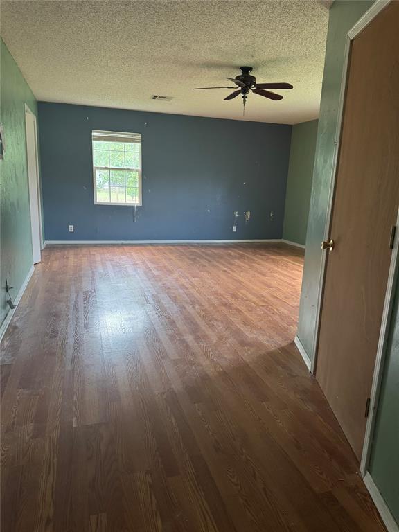 201 S Oak St, Pauls Valley, OK 73075 - unfurnished room featuring a ceiling fan, a textured ceiling, and wood finished floors
