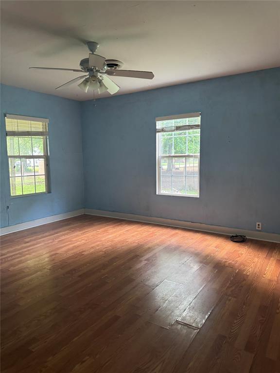 201 S Oak St, Pauls Valley, OK 73075 - spare room with healthy amount of natural light, wood finished floors, and ceiling fan
