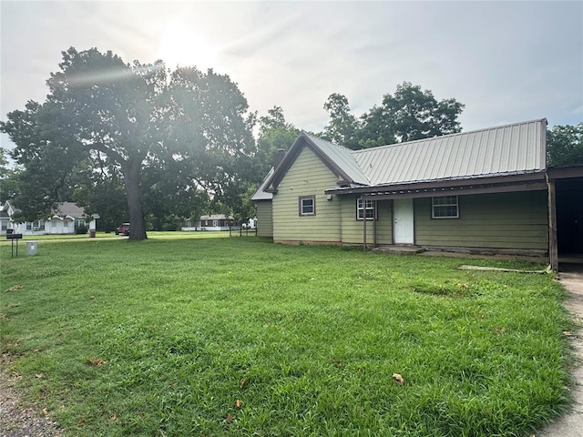 201 S Oak St, Pauls Valley, OK 73075 - rear view of property featuring a metal roof, a lawn, and an attached carport