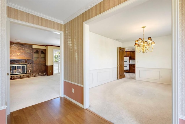 2709 NW 60th St, Oklahoma City, OK 73112 - unfurnished dining area featuring wallpapered walls, a chandelier, a wainscoted wall, carpet flooring, and wood finished floors