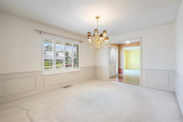 2709 NW 60th St, Oklahoma City, OK 73112 - carpeted empty room with a chandelier, wainscoting, and a decorative wall