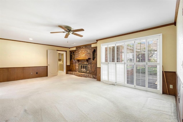 2709 NW 60th St, Oklahoma City, OK 73112 - unfurnished living room with a fireplace, ornamental molding, carpet flooring, a ceiling fan, and a wainscoted wall