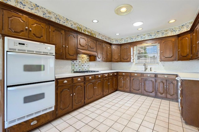 2709 NW 60th St, Oklahoma City, OK 73112 - kitchen featuring double oven, stainless steel gas cooktop, light countertops, light tile patterned floors, and backsplash