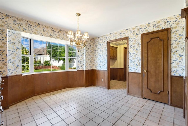 2709 NW 60th St, Oklahoma City, OK 73112 - unfurnished dining area featuring a wainscoted wall, a chandelier, wallpapered walls, light tile patterned floors, and wood walls