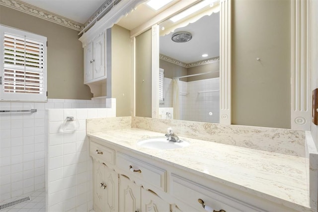 2709 NW 60th St, Oklahoma City, OK 73112 - full bathroom with tiled shower, vanity, tile walls, ornamental molding, and wainscoting
