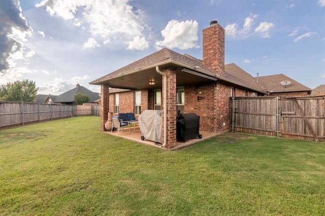 3101 Firewheel Rd, Edmond, OK 73013 - back of house featuring a patio area, a chimney, a fenced backyard, brick siding, and a gate