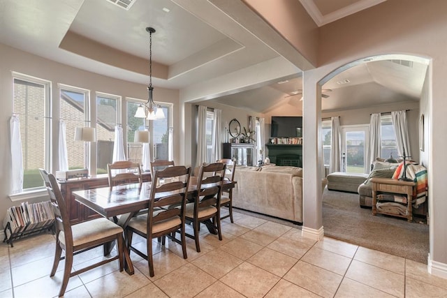 3101 Firewheel Rd, Edmond, OK 73013 - dining room featuring light tile patterned floors, arched walkways, a raised ceiling, and light carpet