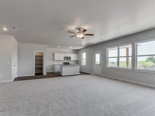 13172 Mannington Rd, Edmond, OK 73025 - unfurnished living room with dark colored carpet and a ceiling fan