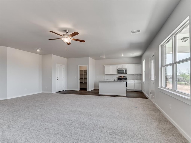 13172 Mannington Rd, Edmond, OK 73025 - unfurnished living room featuring dark colored carpet and ceiling fan