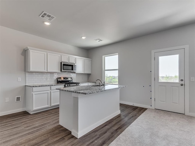 13172 Mannington Rd, Edmond, OK 73025 - kitchen featuring stainless steel appliances, white cabinetry, decorative backsplash, light stone counters, and recessed lighting