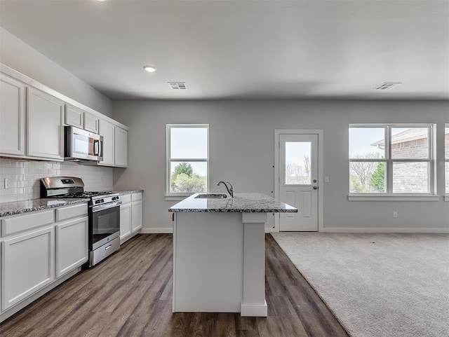 13172 Mannington Rd, Edmond, OK 73025 - kitchen featuring stainless steel appliances, light stone counters, healthy amount of natural light, tasteful backsplash, and recessed lighting
