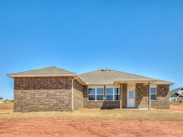 13172 Mannington Rd, Edmond, OK 73025 - rear view of property with brick siding, roof with shingles, and a yard