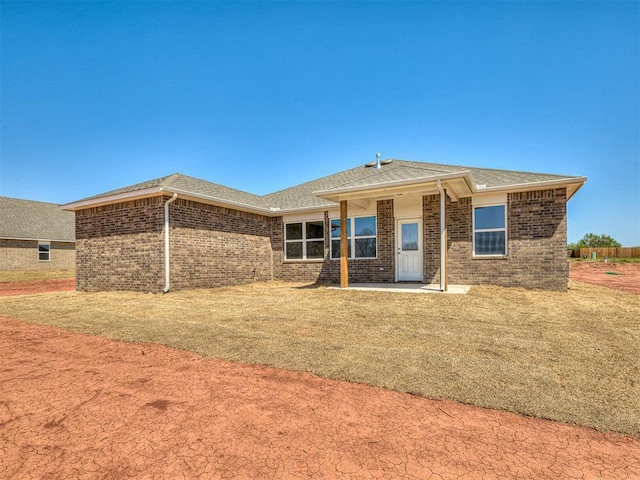 13172 Mannington Rd, Edmond, OK 73025 - back of property with brick siding, a shingled roof, and a patio