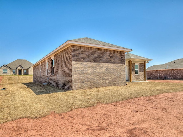 13172 Mannington Rd, Edmond, OK 73025 - rear view of house featuring brick siding and roof with shingles