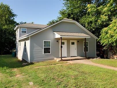 bungalow-style home featuring a front lawn and covered porch