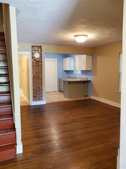 kitchen with a peninsula, a kitchen bar, light wood-type flooring, and white cabinets