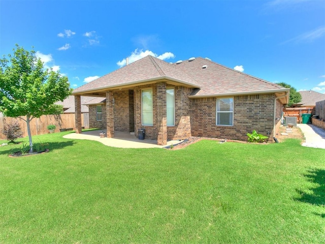 12824 NW 6th St, Yukon, OK 73099 - back of property featuring a patio, brick siding, roof with shingles, and a fenced backyard