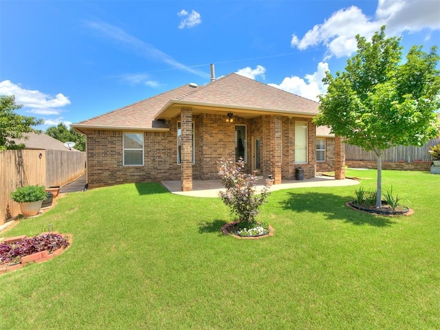 12824 NW 6th St, Yukon, OK 73099 - rear view of property featuring a fenced backyard, brick siding, a patio, and roof with shingles