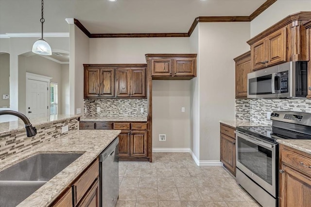 600 Nathan Way, Yukon, OK 73099 - kitchen with stainless steel appliances, ornamental molding, tasteful backsplash, light stone counters, and hanging light fixtures