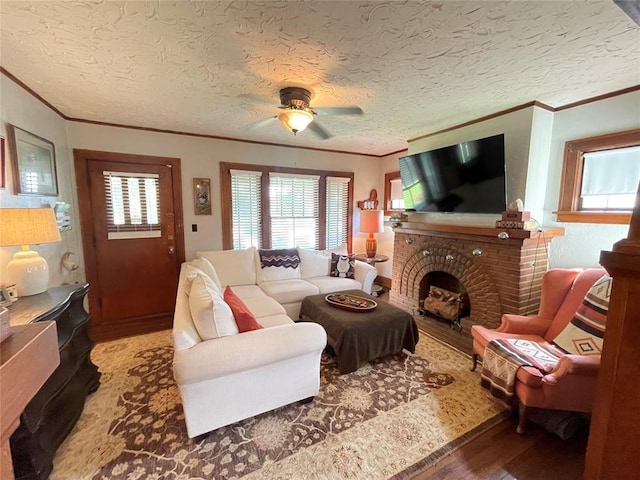 1845 W Park Pl, Oklahoma City, OK 73106 - living room featuring ornamental molding, wood finished floors, a ceiling fan, a fireplace, and a textured ceiling