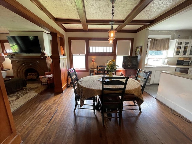 1845 W Park Pl, Oklahoma City, OK 73106 - dining space with dark wood-style flooring, a brick fireplace, coffered ceiling, and beam ceiling