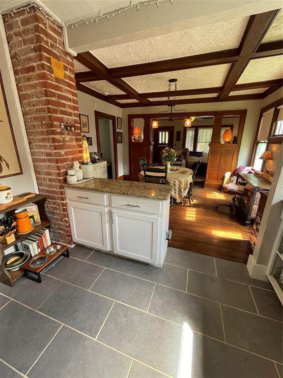 1845 W Park Pl, Oklahoma City, OK 73106 - kitchen featuring a peninsula, white cabinetry, coffered ceiling, dark tile patterned flooring, and beam ceiling