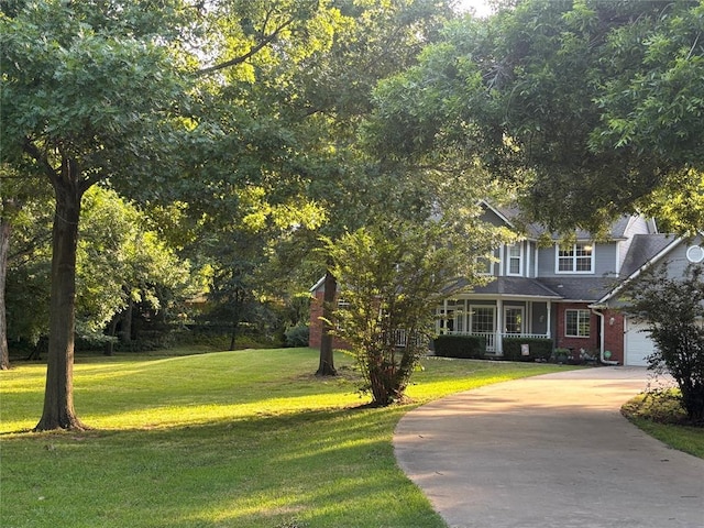 1800 N Elm Ave, Shawnee, OK 74804 - obstructed view of property featuring a front yard, driveway, brick siding, and covered porch