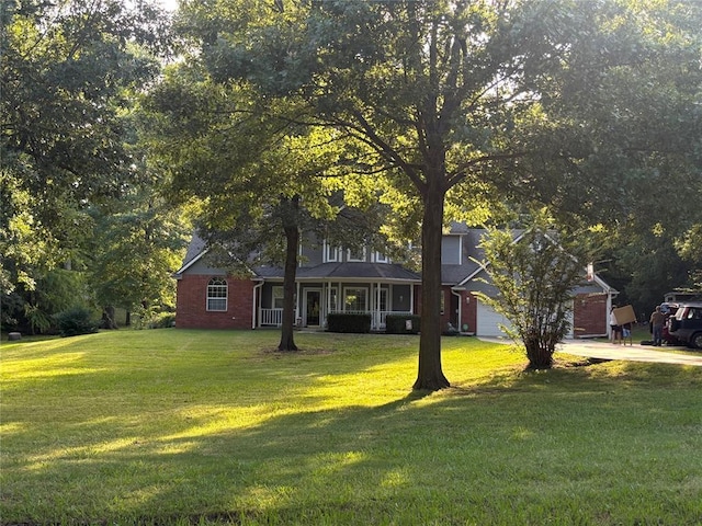 1800 N Elm Ave, Shawnee, OK 74804 - view of front of house featuring a front yard, concrete driveway, covered porch, and brick siding