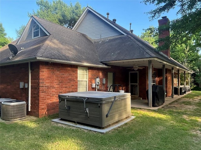 1800 N Elm Ave, Shawnee, OK 74804 - back of property featuring a hot tub, brick siding, a patio area, ceiling fan, and a lawn