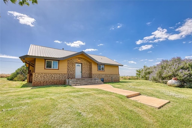 22807 E 1070th Rd, Clinton, OK 73601 - view of front facade featuring brick siding, a front yard, and a metal roof