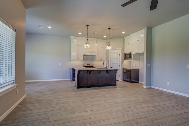 9120 NW 123rd St, Yukon, OK 73099 - kitchen featuring built in microwave, ceiling fan, white cabinetry, light wood-style flooring, and recessed lighting