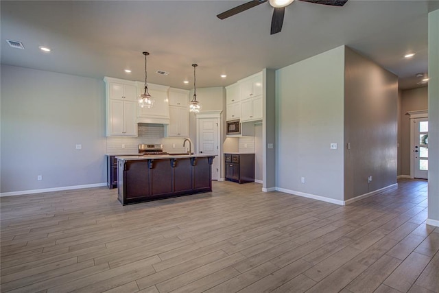 9120 NW 123rd St, Yukon, OK 73099 - kitchen featuring open floor plan, stainless steel appliances, a ceiling fan, light wood-style floors, and white cabinets
