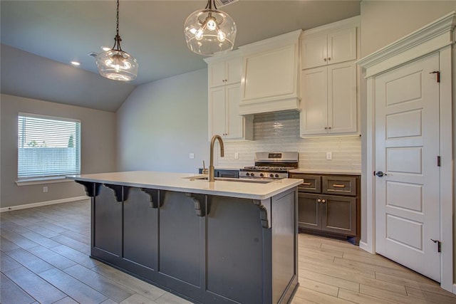 9120 NW 123rd St, Yukon, OK 73099 - kitchen featuring stainless steel range oven, lofted ceiling, decorative backsplash, light wood-type flooring, and custom exhaust hood