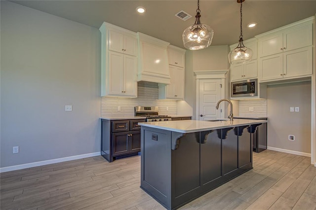 9120 NW 123rd St, Yukon, OK 73099 - kitchen featuring black microwave, stainless steel range oven, white cabinets, light wood-style flooring, and tasteful backsplash