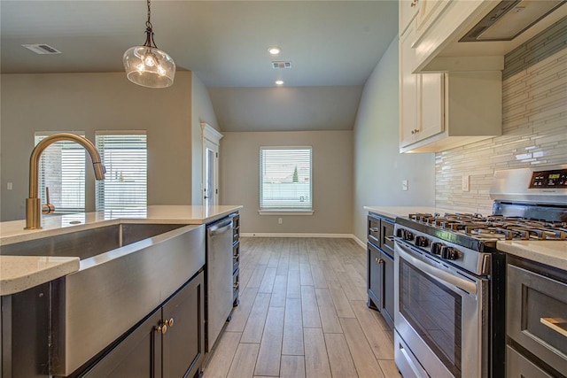 9120 NW 123rd St, Yukon, OK 73099 - kitchen with appliances with stainless steel finishes, extractor fan, tasteful backsplash, light wood finished floors, and decorative light fixtures
