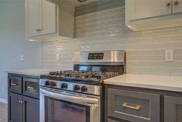 9120 NW 123rd St, Yukon, OK 73099 - kitchen with gas stove, tasteful backsplash, light stone countertops, and white cabinetry