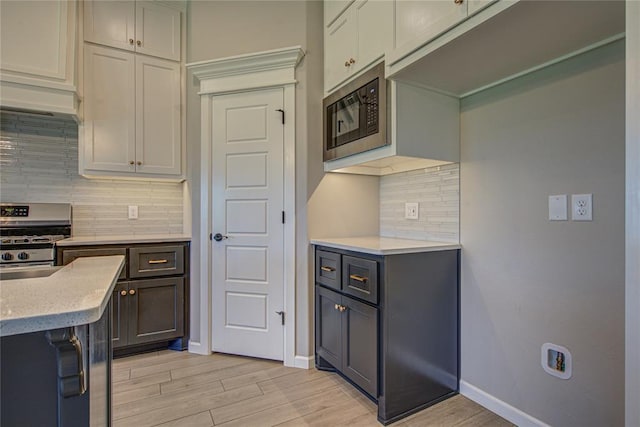 9120 NW 123rd St, Yukon, OK 73099 - kitchen with stainless steel appliances, backsplash, and light wood-style floors