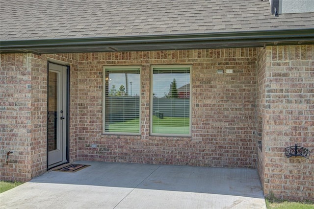 9120 NW 123rd St, Yukon, OK 73099 - doorway to property with roof with shingles and brick siding