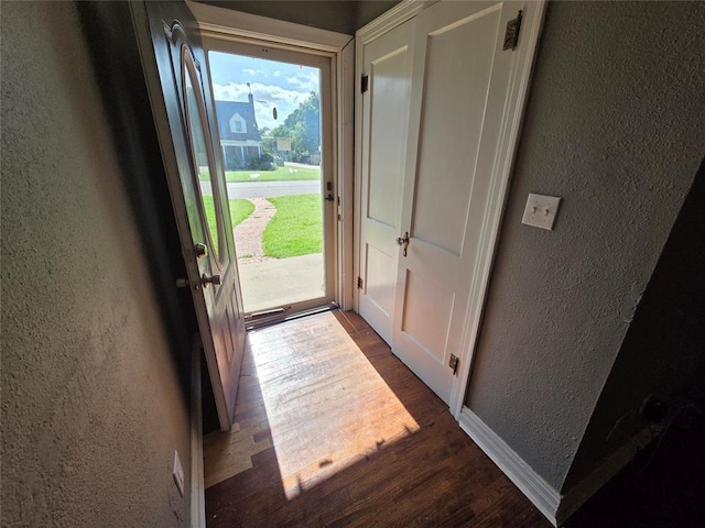 1103 S Hadden Ave, El Reno, OK 73036 - doorway to outside with a textured wall and dark wood-style floors