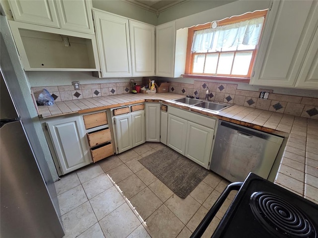 1103 S Hadden Ave, El Reno, OK 73036 - kitchen featuring appliances with stainless steel finishes, tile countertops, open shelves, and backsplash