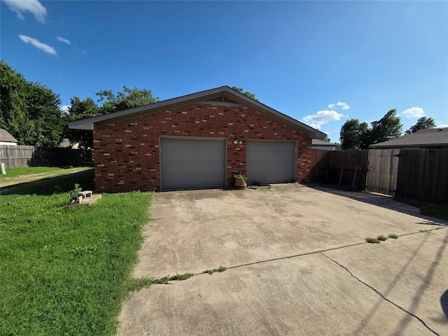 1103 S Hadden Ave, El Reno, OK 73036 - view of home's exterior featuring brick siding, a detached garage, and concrete driveway