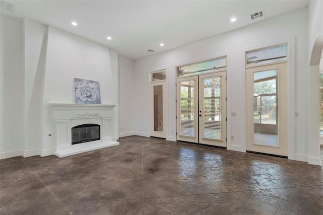 15016 Kurdson Way, Edmond, OK 73013 - unfurnished living room featuring french doors, concrete flooring, recessed lighting, and a glass covered fireplace