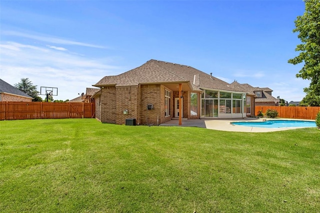 15016 Kurdson Way, Edmond, OK 73013 - back of property featuring a fenced backyard, brick siding, a patio area, and a sunroom